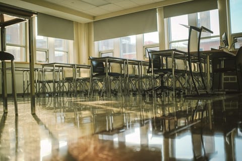 Salle de classe vide aux tables alignées sur un sol brillant
