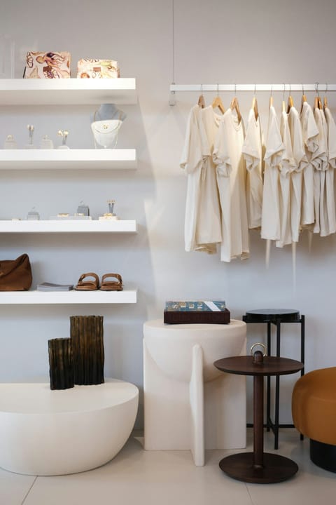Intérieur de boutique clair et rangé, étagères et portants de vêtements